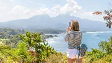 a person standing on a hill overlooking a body of water